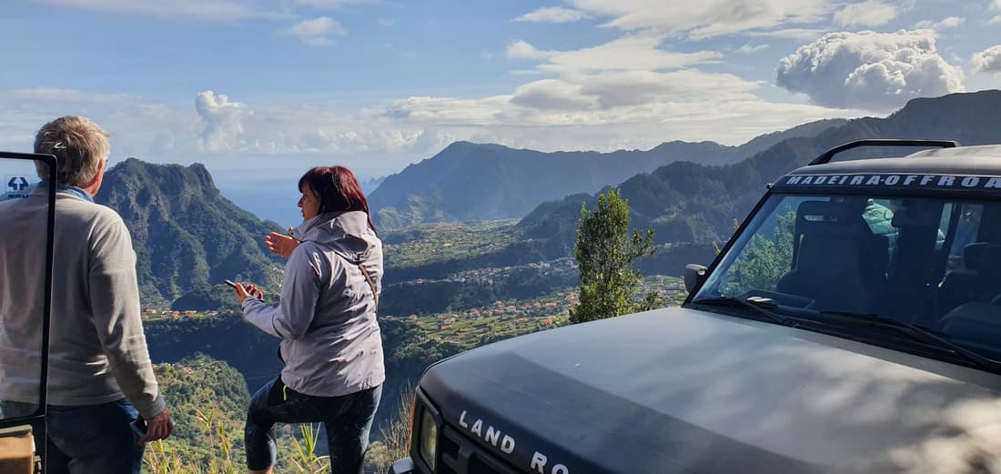 Tour guests enjoying a mountain viewpoint beside the Madeira Off Road Jeep