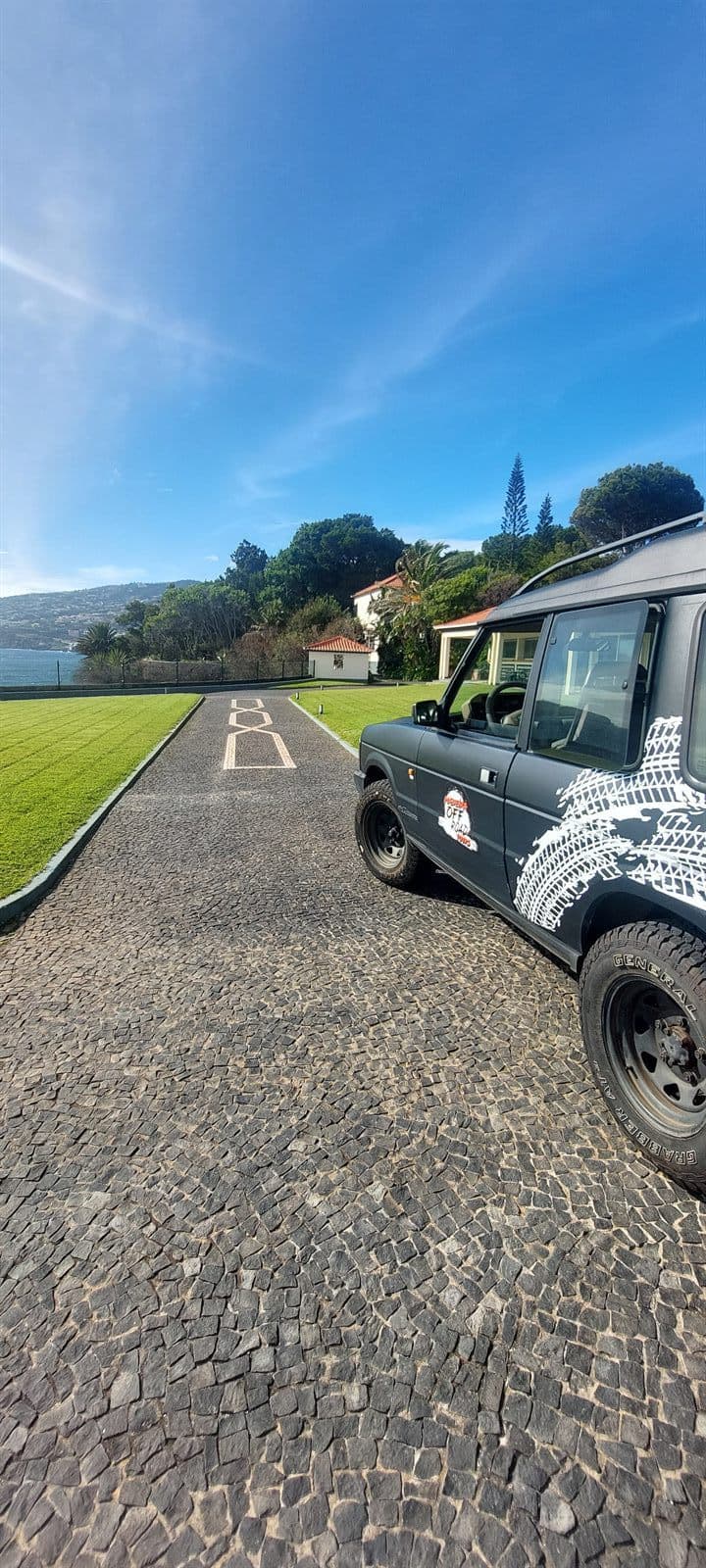 Land Rover Discovery with a coastal village behind