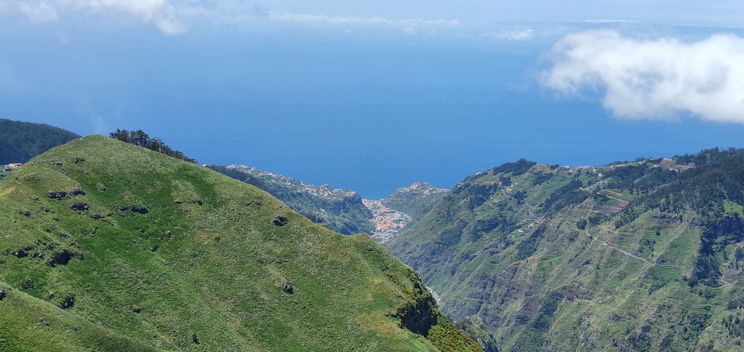 Green ridges falling away to Machico bay under a clear sky