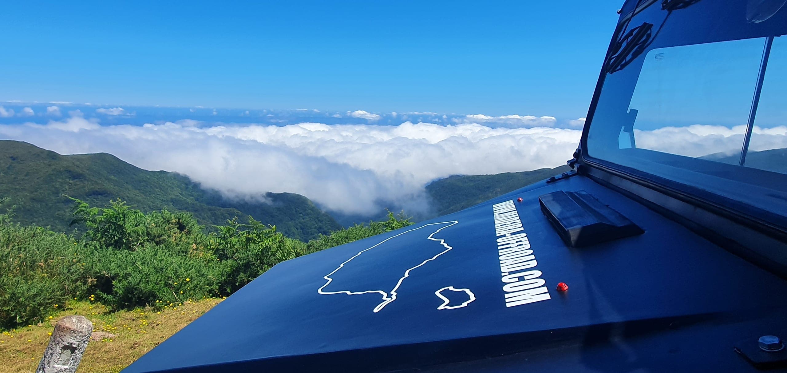 The Madeira Off Road Jeep at a mountain viewpoint, the island outlined on the bonnet and a sea of clouds below